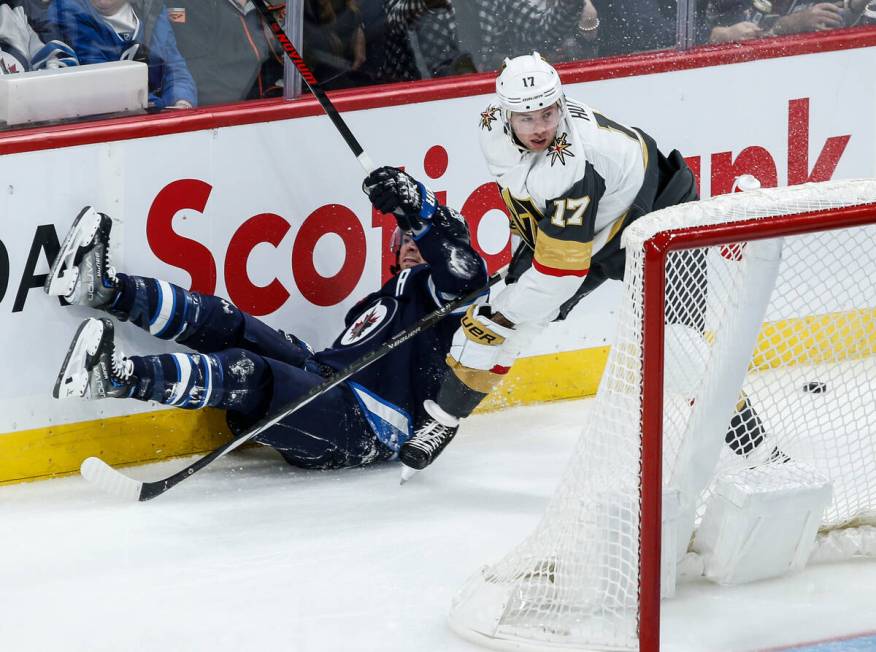 Vegas Golden Knights' Ben Hutton (17) defends against Winnipeg Jets' Mark Scheifele, left, duri ...