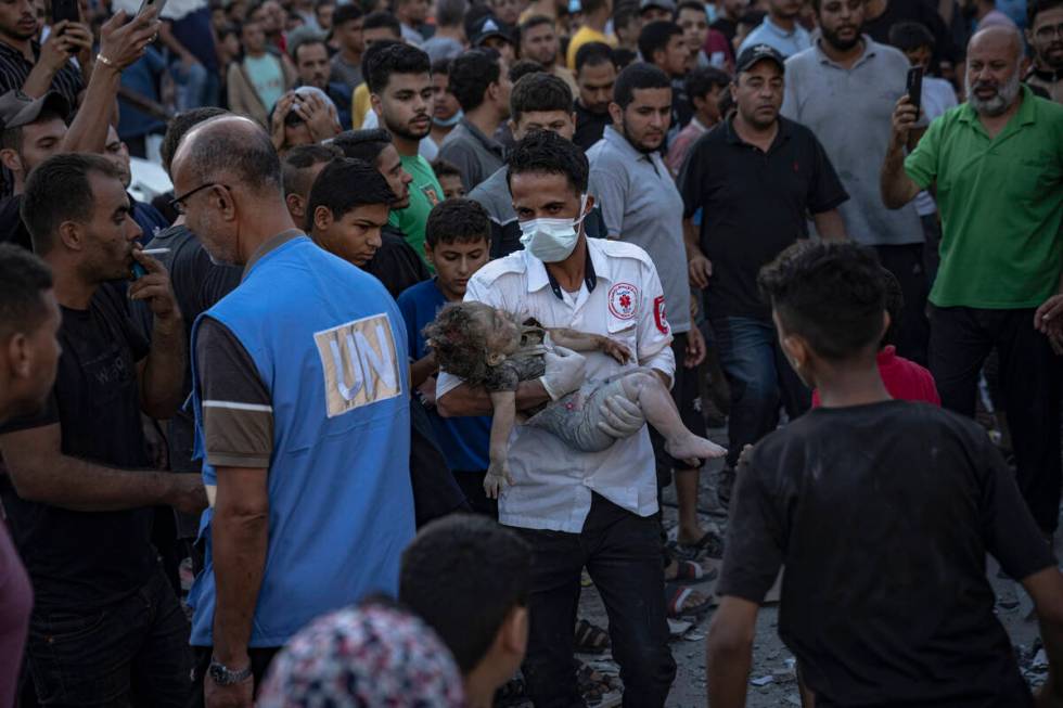 A child is carried from the rubble of a building after an airstrike in Khan Younis, Gaza Strip, ...