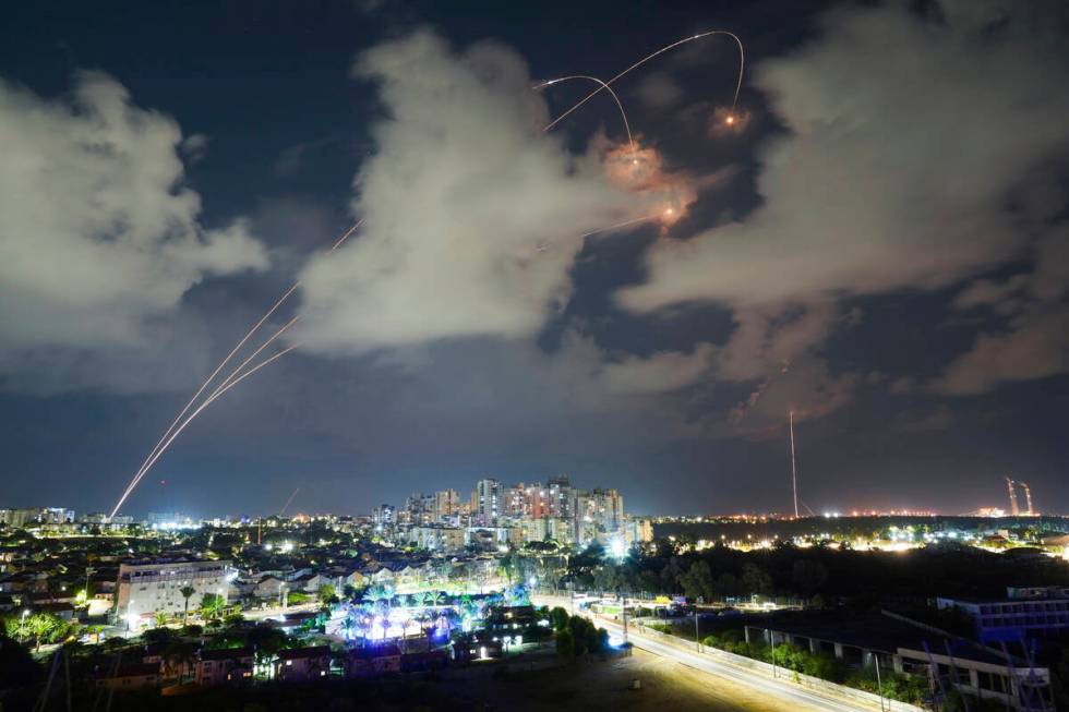 File - Rockets from the Israeli Iron Dome air defense system maneuver to intercept a rocket fir ...