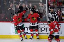 Chicago Blackhawks' Connor Bedard (98) celebrates with teammate Ryan Donato (8) after scoring a ...