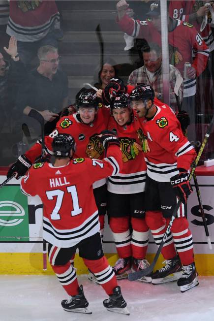 Chicago Blackhawks' Connor Bedard (98) celebrates with teammates Ryan Donato (8), Seth Jones (4 ...