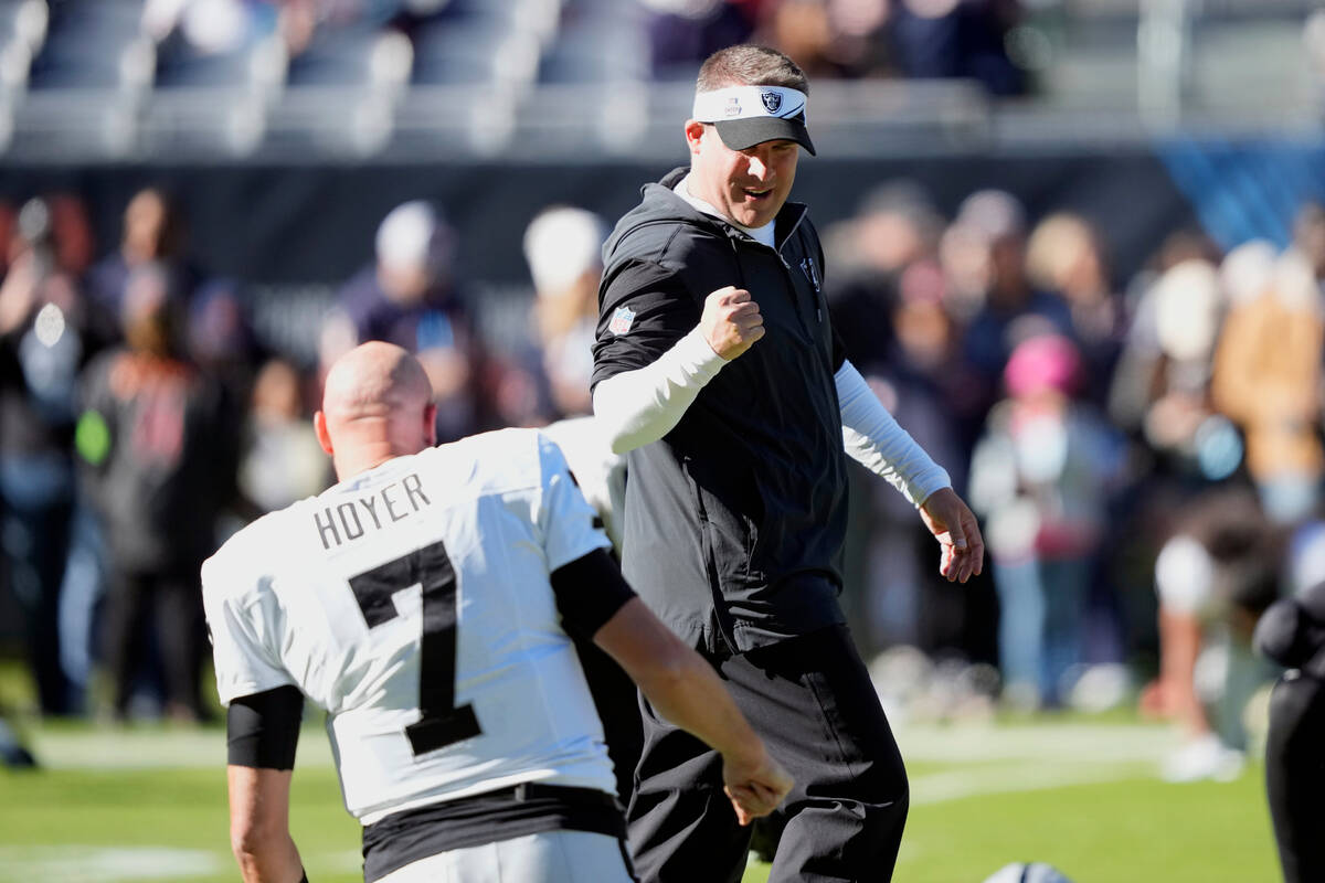 Las Vegas Raiders head coach Josh McDaniels talks with quarterback Brian Hoyer (7) before an NF ...