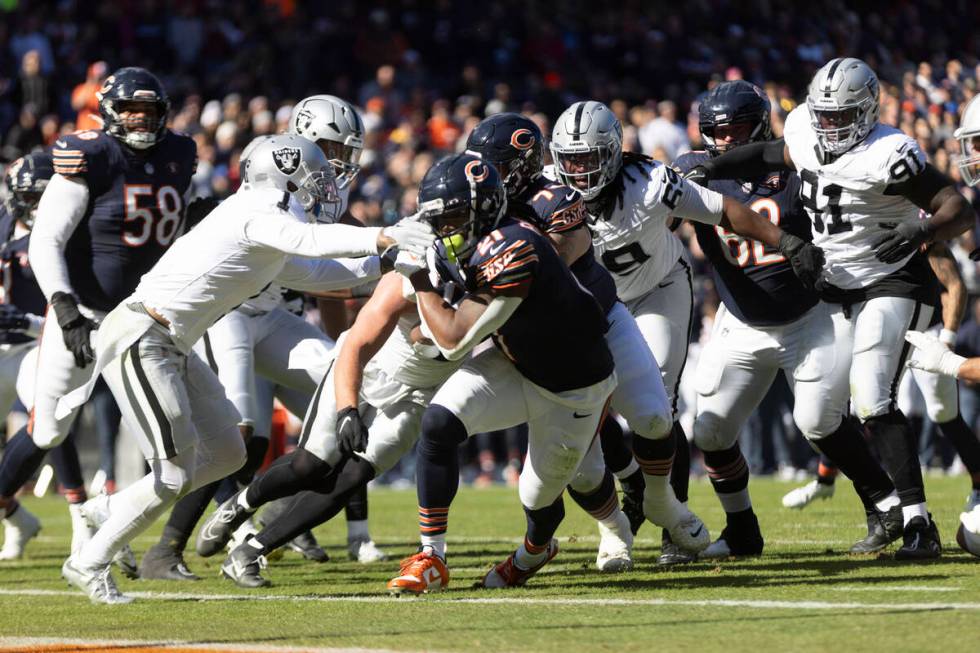 Chicago Bears running back D'Onta Foreman (21) rushes to the end zone with Raiders safety Marcu ...