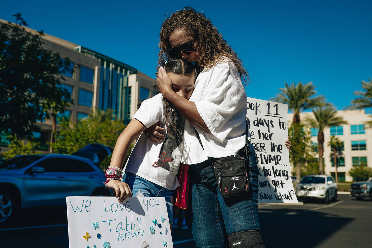 Regina Lacerda, right, the mother of Tabatha Tozzi, hugs Macy Diaz, 8, during a demonstration i ...