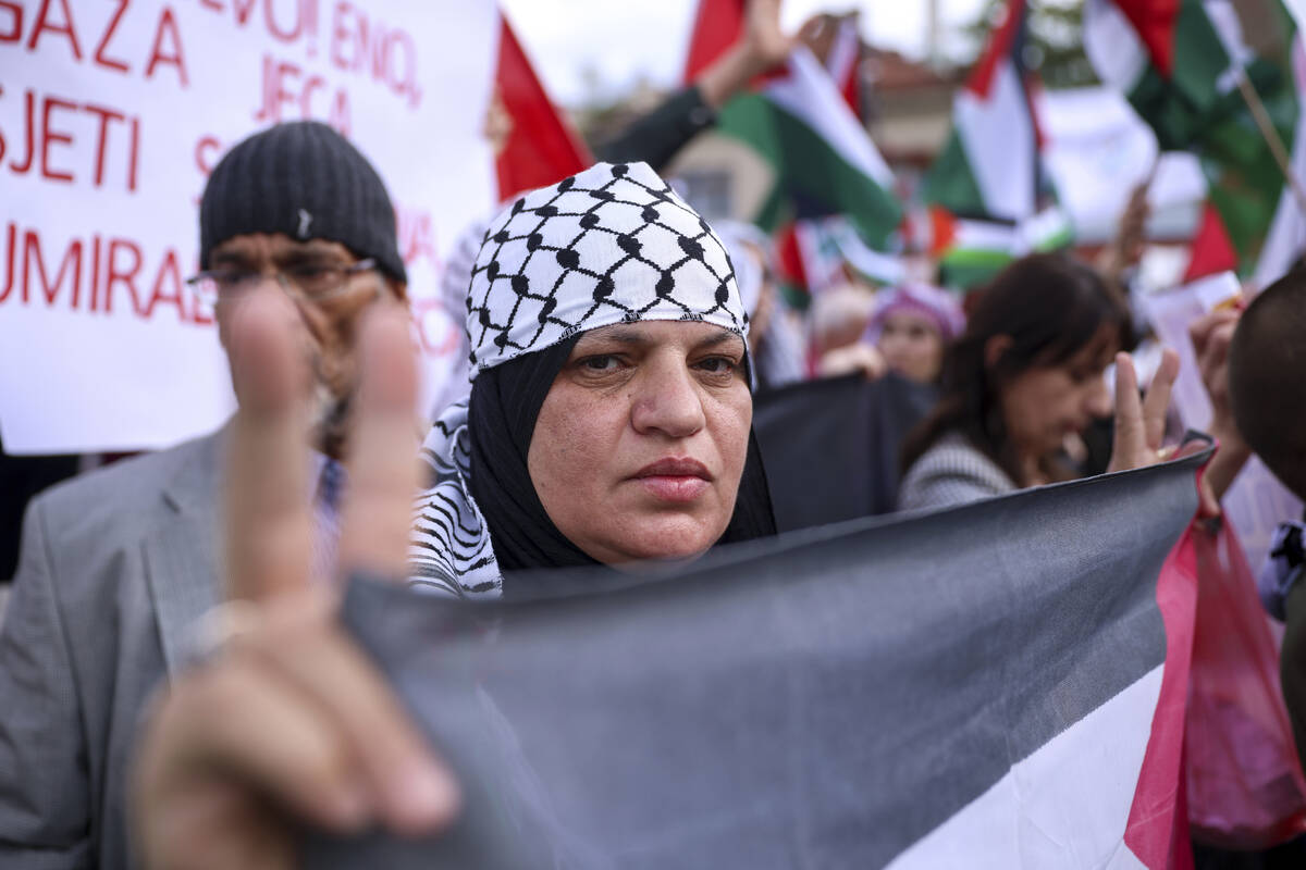 A woman shows a peace sign during a protest against Israel and in support of Palestinians in Sa ...