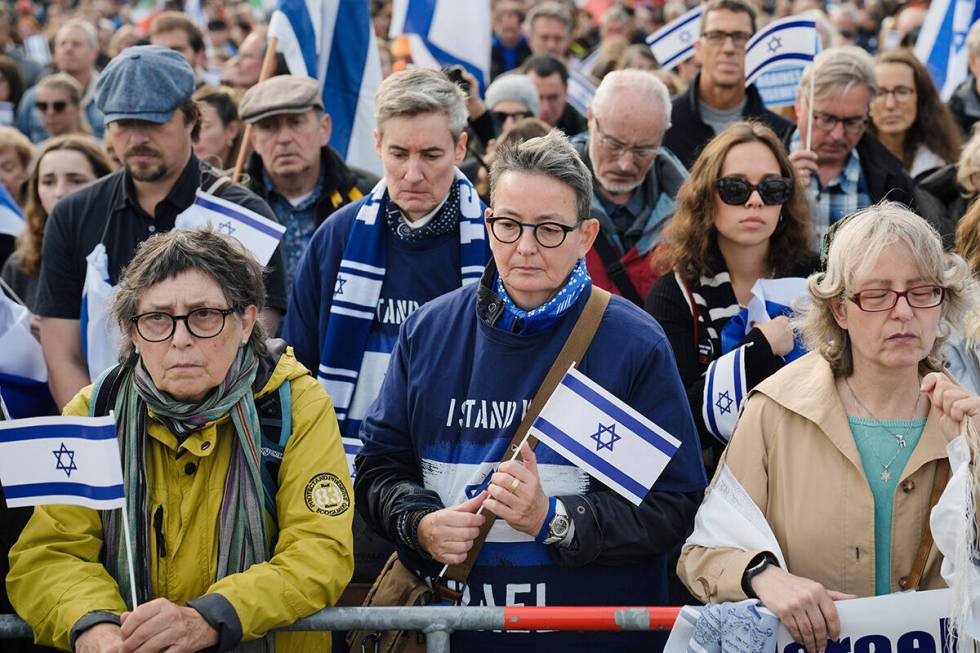 People hold a minute of silence to commemorate the victims of the Hamas attack on Israel during ...