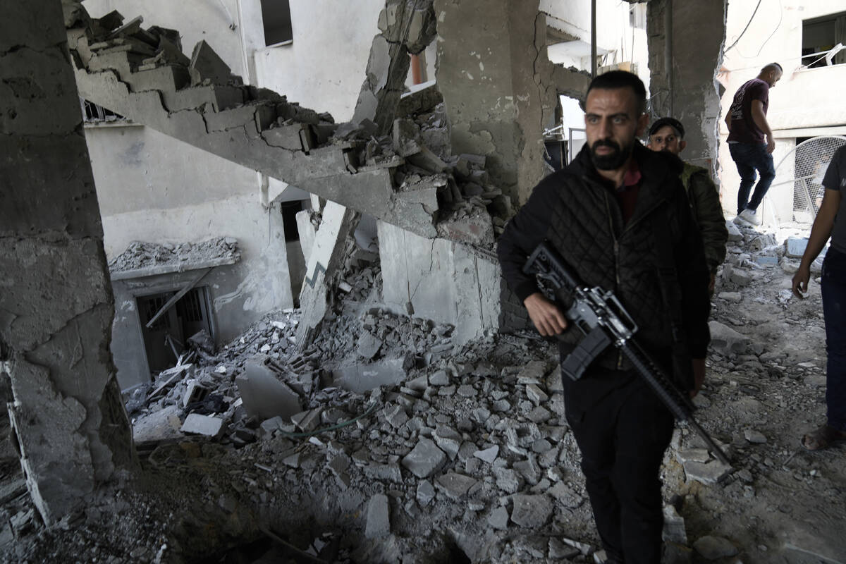 Palestinians inspect the damage after an Israeli strike hit a compound beneath a mosque in Jeni ...