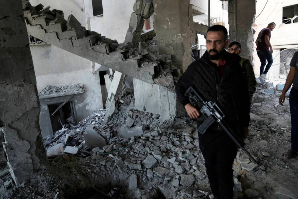 Palestinians inspect the damage after an Israeli strike hit a compound beneath a mosque in Jeni ...