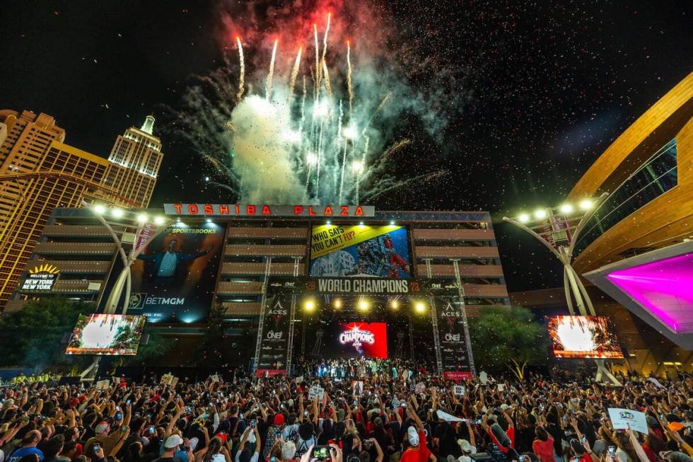 Aces players party on stage as fireworks erupt overhead during their championship celebration ...