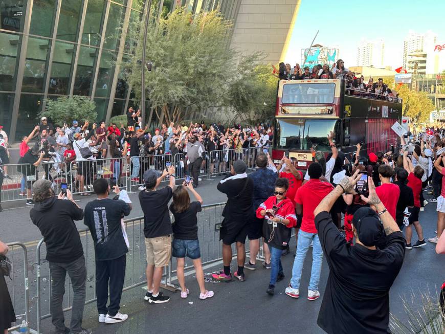 Fans watch the Las Vegas Aces head up the Las Vegas Strip on their way to a repeat world champi ...