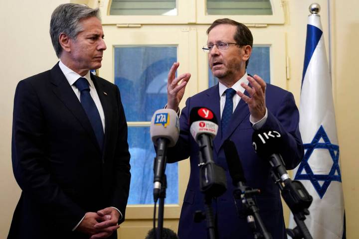 Israel's President Isaac Herzog stands with U.S. Secretary of State Antony Blinken on Oct. 12, ...