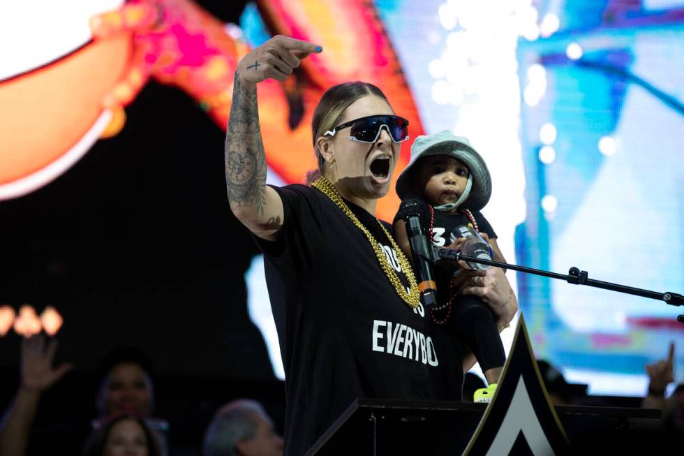 Las Vegas Aces forward Cayla George (13) carries her daughter Pearl while pumping up the crowd ...