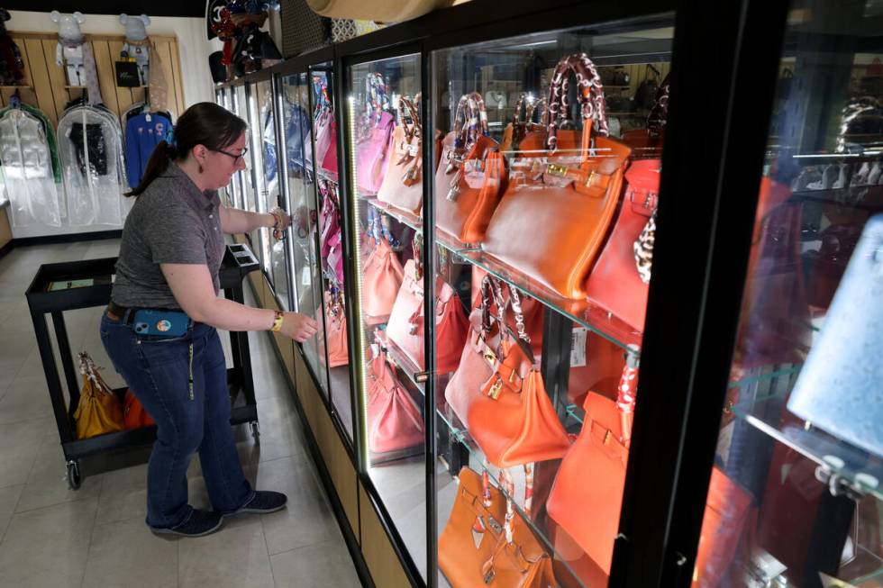 Associate Dana Olsen displays designer handbags at Max Pawn Luxury on South Decatur Boulevard i ...