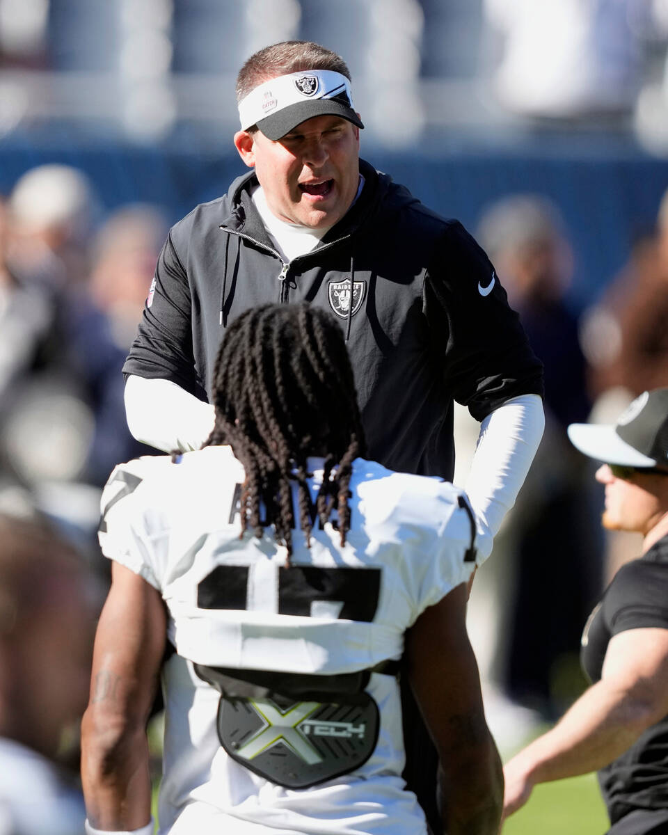 Las Vegas Raiders head coach Josh McDaniels talks with wide receiver Davante Adams before an NF ...