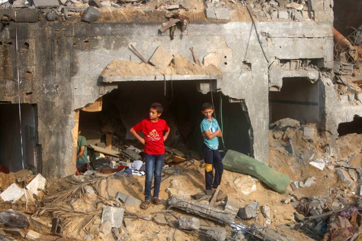 Palestinians inspect the damage of a destroyed house that was hit by an Israeli airstrike in to ...