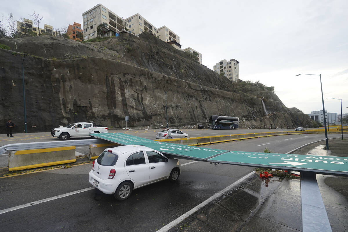 A traffic sign lays on a car after Hurricane Otis ripped through Acapulco, Mexico, Wednesday, O ...