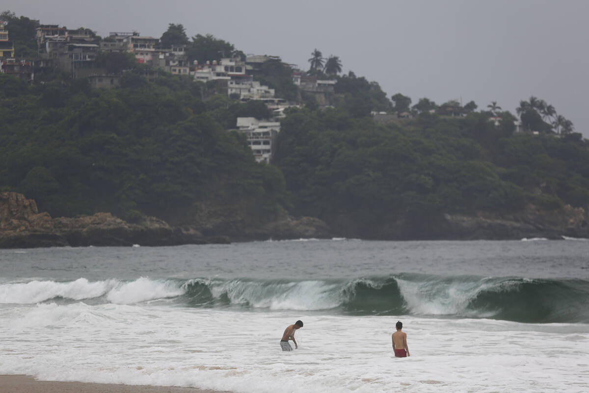 FILE - Tourists swim in Acapulco, Mexico, Oct. 24, 2023. Hurricane Otis turned from mild to mon ...