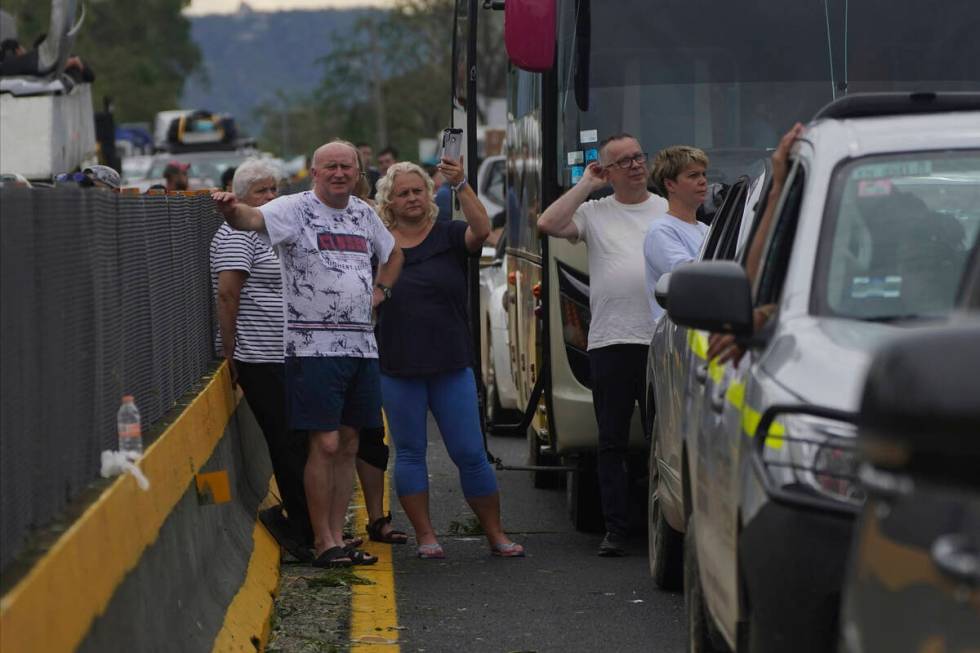 People wait outside their cars as they wait for repair crews to clear the roads after Hurricane ...