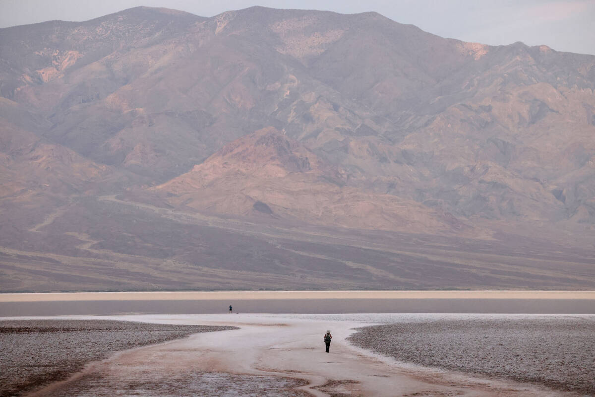 Visitors check out a rare lake in Badwater Basin in the recently reopened Death Valley National ...