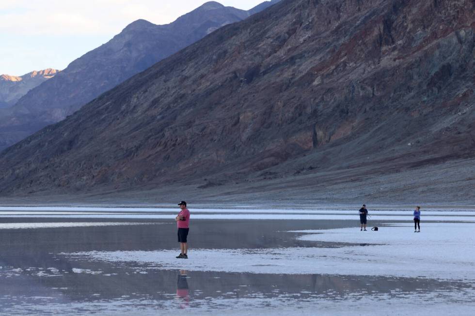 Visitors check out a rare lake in Badwater Basin in the recently reopened Death Valley National ...