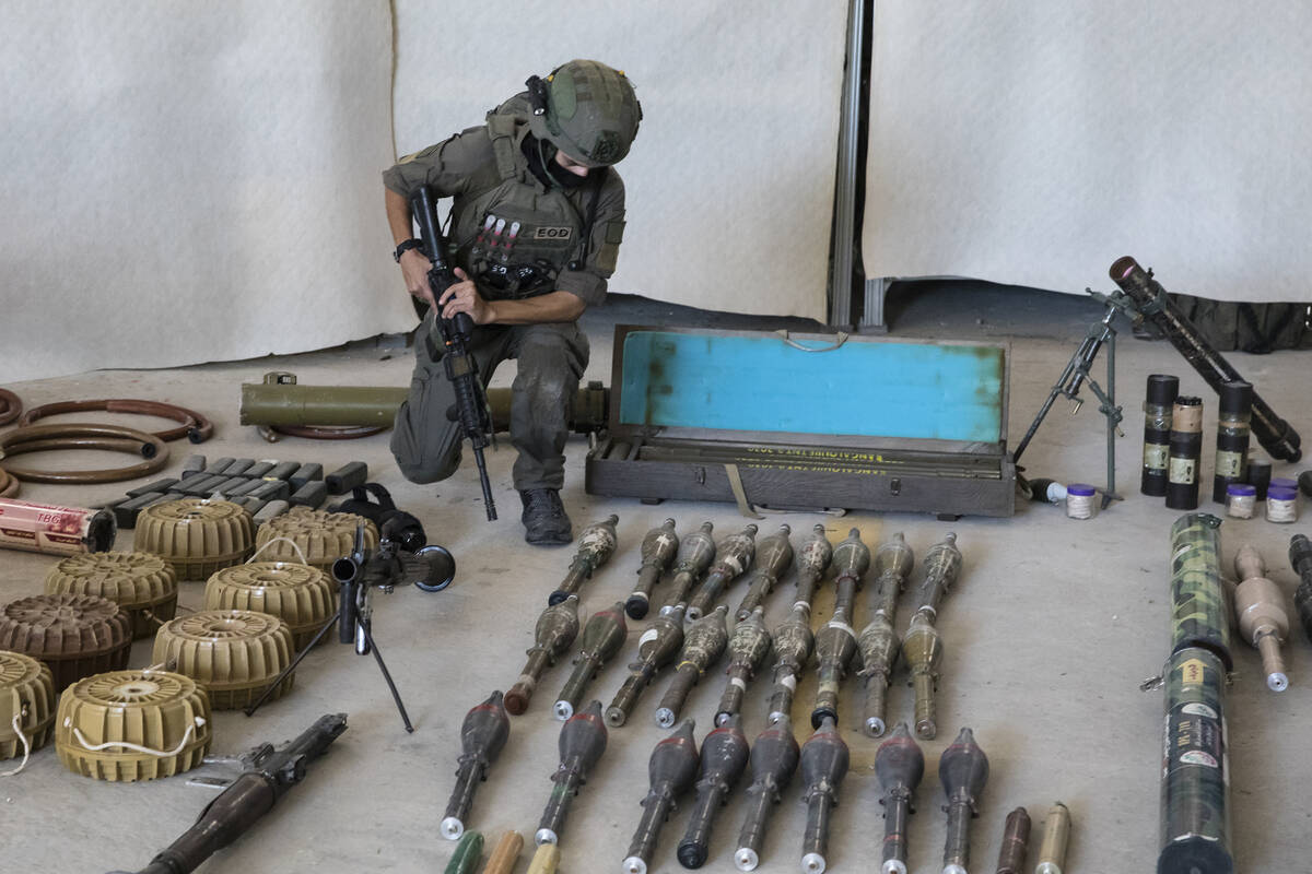 An Israeli soldier displays military equipment and ammunition that Hamas and Palestinian milita ...