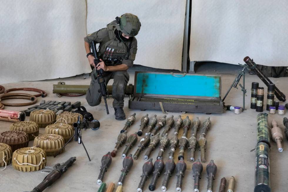 An Israeli soldier displays military equipment and ammunition that Hamas and Palestinian milita ...