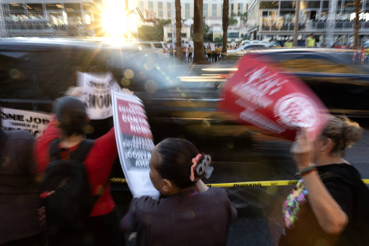 Culinary union members wave signs at passing traffic during a rally along Las Vegas Boulevard o ...