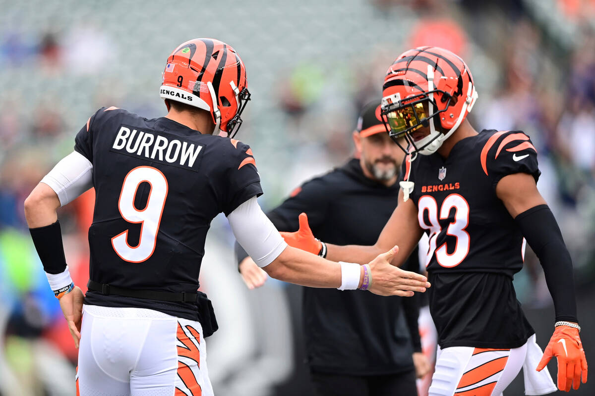 Cincinnati Bengals quarterback Joe Burrow (9) high fives wide receiver Tyler Boyd (83) before a ...