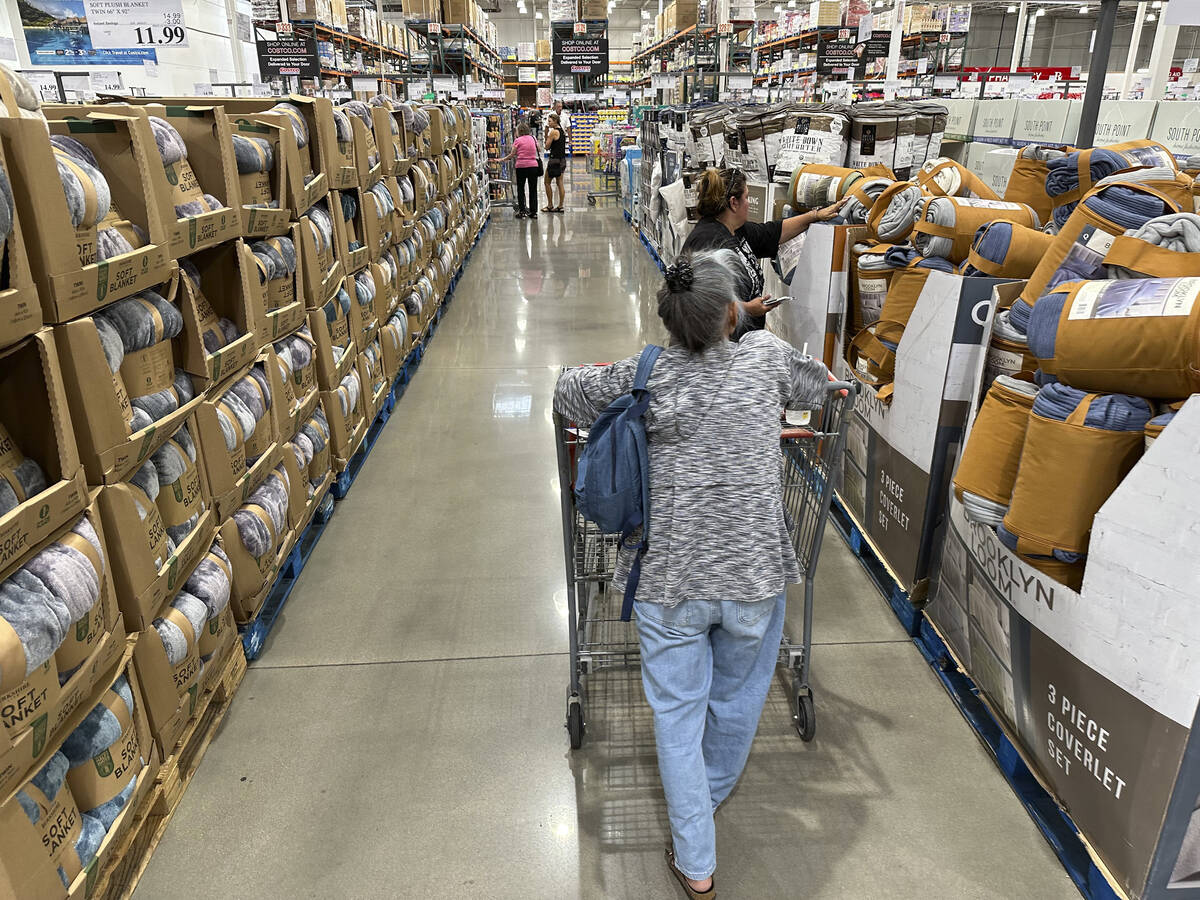 File - Shoppers look over blankets on sale in a Costco warehouse on Aug. 24, 2023, in Sheridan, ...