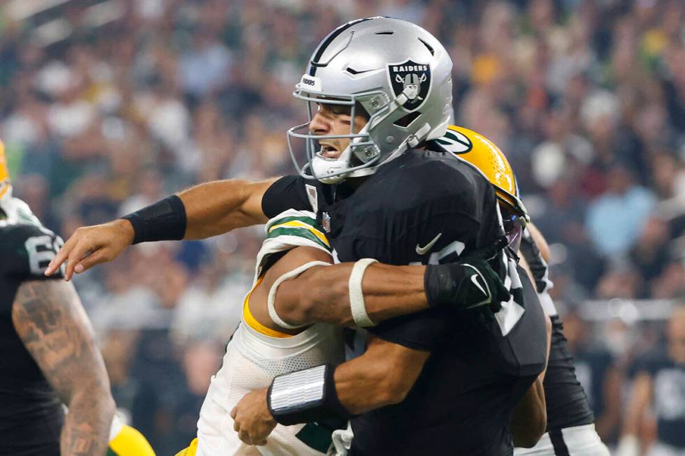 Raiders quarterback Jimmy Garoppolo (10) throws a pass under pressure from the Green Bay Packer ...