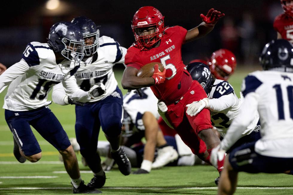 Arbor View running back Makhai Donaldson (5) runs the ball through Shadow Ridge linebacker Dieg ...