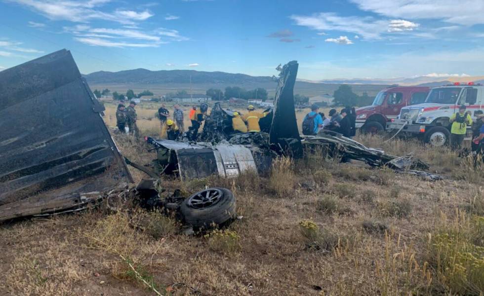 Members of Truckee Meadows Fire & Rescue and other officials look over aircraft wreckage Sept. ...