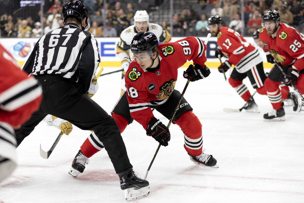 Blackhawks center Connor Bedard (98) faces off against Golden Knights center Jack Eichel, obscu ...