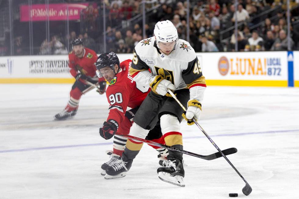 Golden Knights center Ivan Barbashev (49) maneuvers the puck away from Blackhawks center Tyler ...