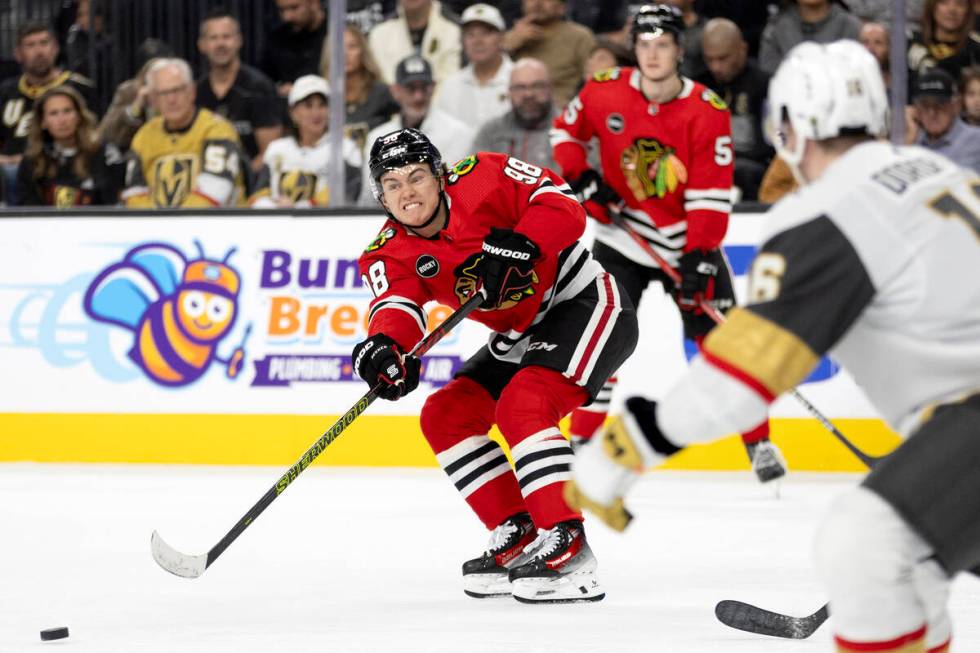 Blackhawks center Connor Bedard (98) passes the puck up the ice while Golden Knights left wing ...