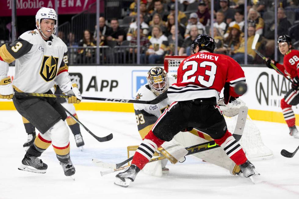 Golden Knights goaltender Adin Hill (33) and defenseman Brayden McNabb (3) watch the puck after ...