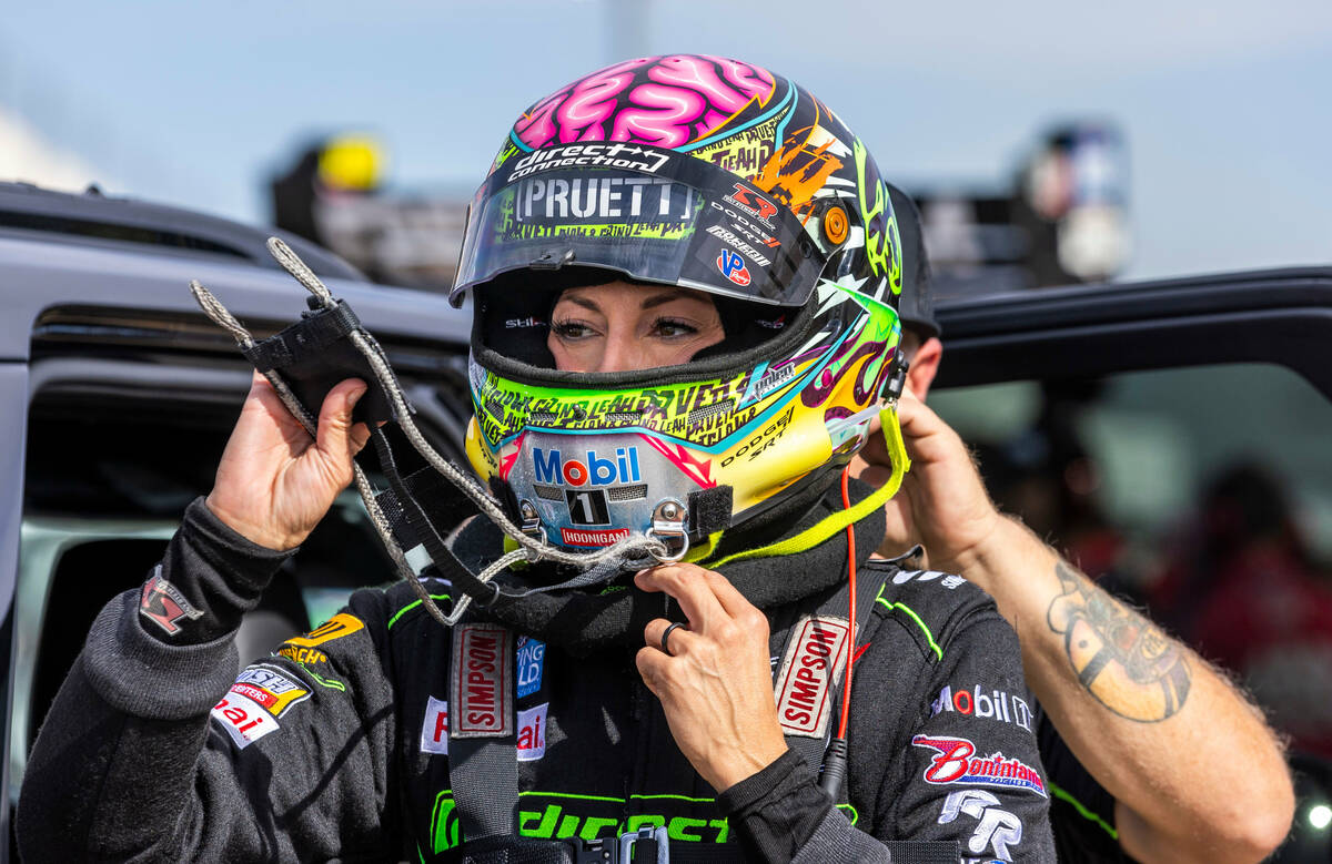 Top Fuel racer Leah Pruett is assisted with her racing suit before a during a qualifying sessio ...