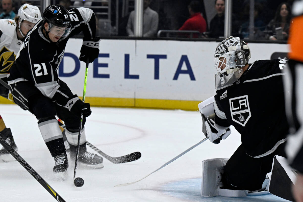 Los Angeles Kings defenseman Jordan Spence (21) controls the puck in front of Kings goaltender ...