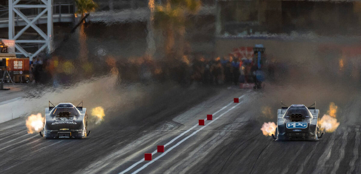 Robert Hight, left, and Bob Tasca III battle during a Funny Car qualifying session in the NHRA ...