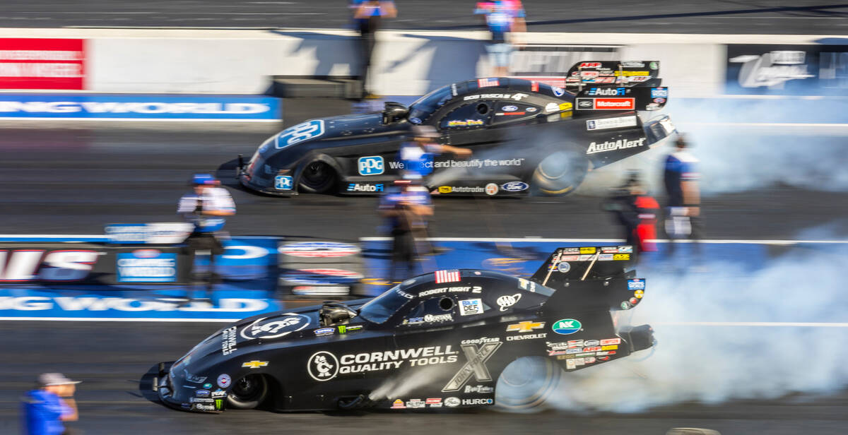 Bob Tasca III, top, and Robert Hight burn their tires during a Funny Car qualifying session in ...