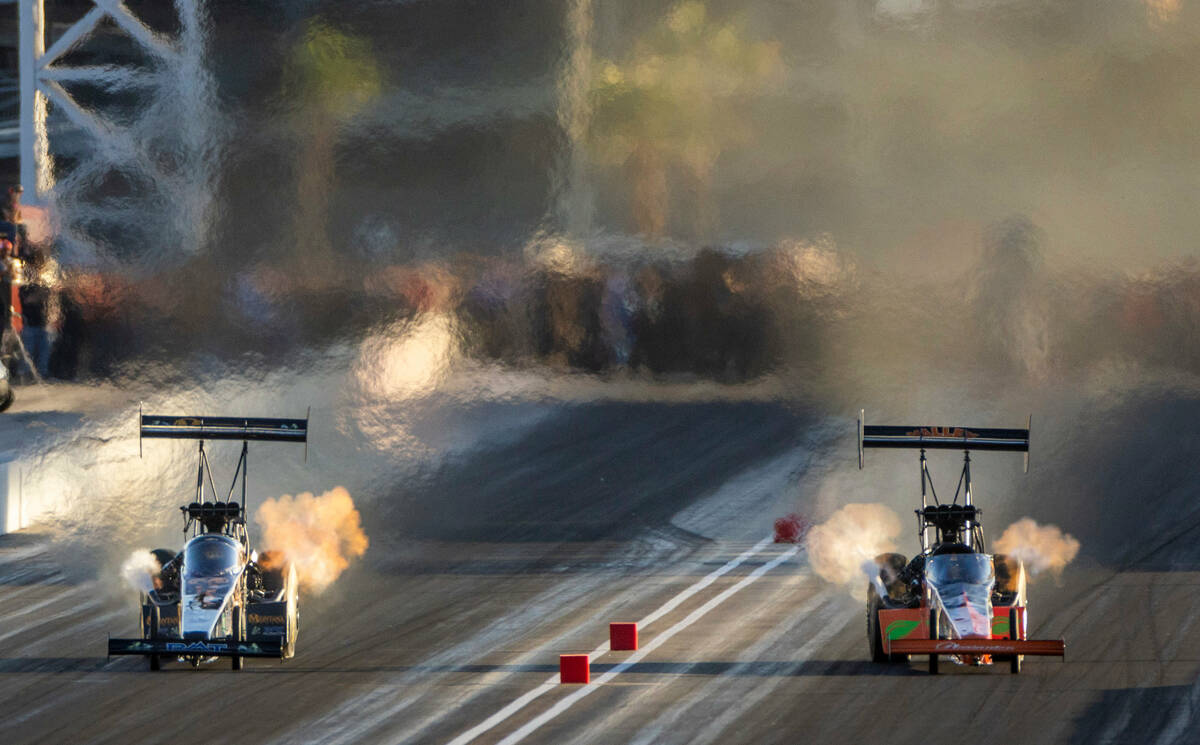 Austin Prock, left, and Mike Salinas battle during a Top Fuel qualifying session in the NHRA Ne ...