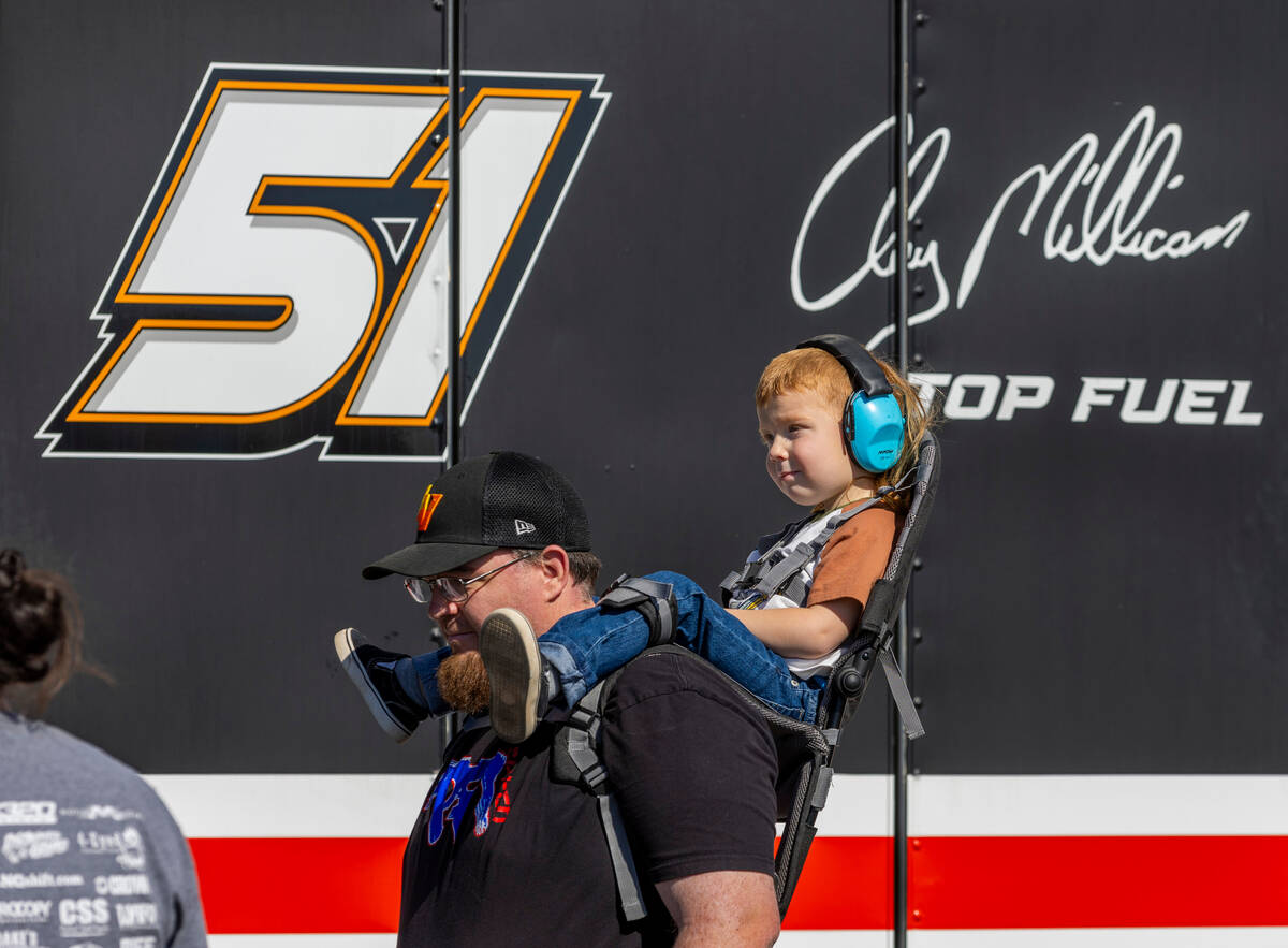 A young fan sits comfortably while viewing cars during a qualifying session in the NHRA Nevada ...