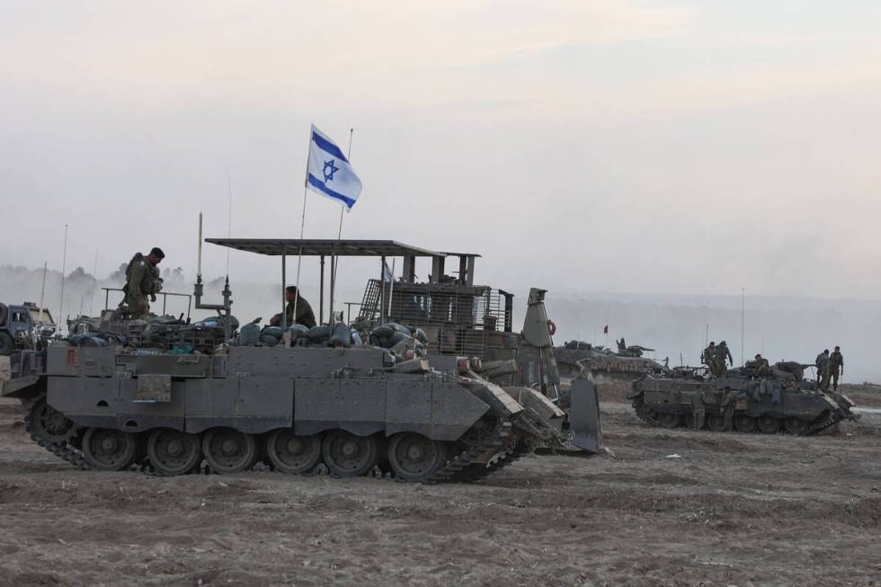 Israeli armored vehicles and bulldozers gather near the border with Gaza before entering the Pa ...