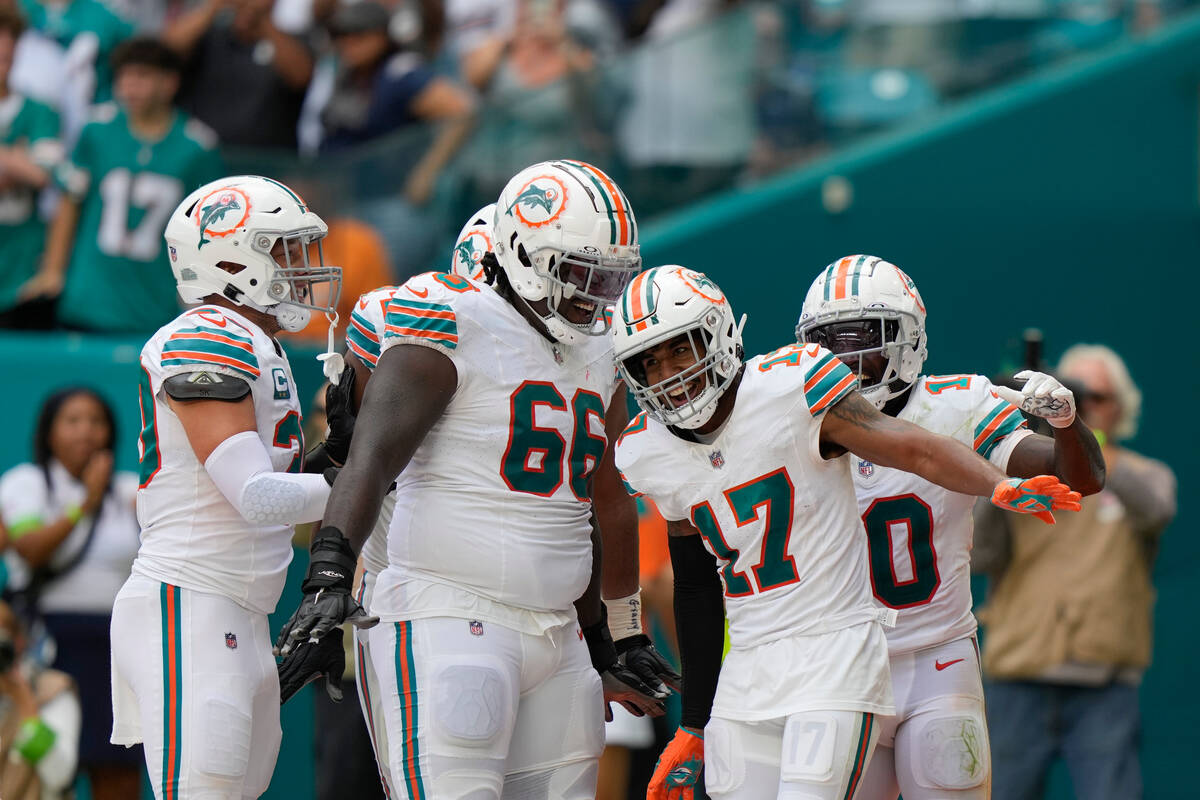 Miami Dolphins wide receiver Jaylen Waddle (17) celebrates with teammates after scoring a touch ...