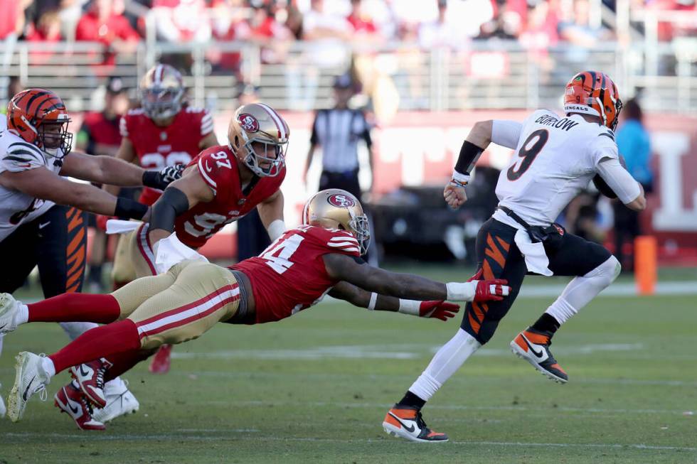 Cincinnati Bengals quarterback Joe Burrow (9) evades San Francisco 49ers defensive end Clelin F ...