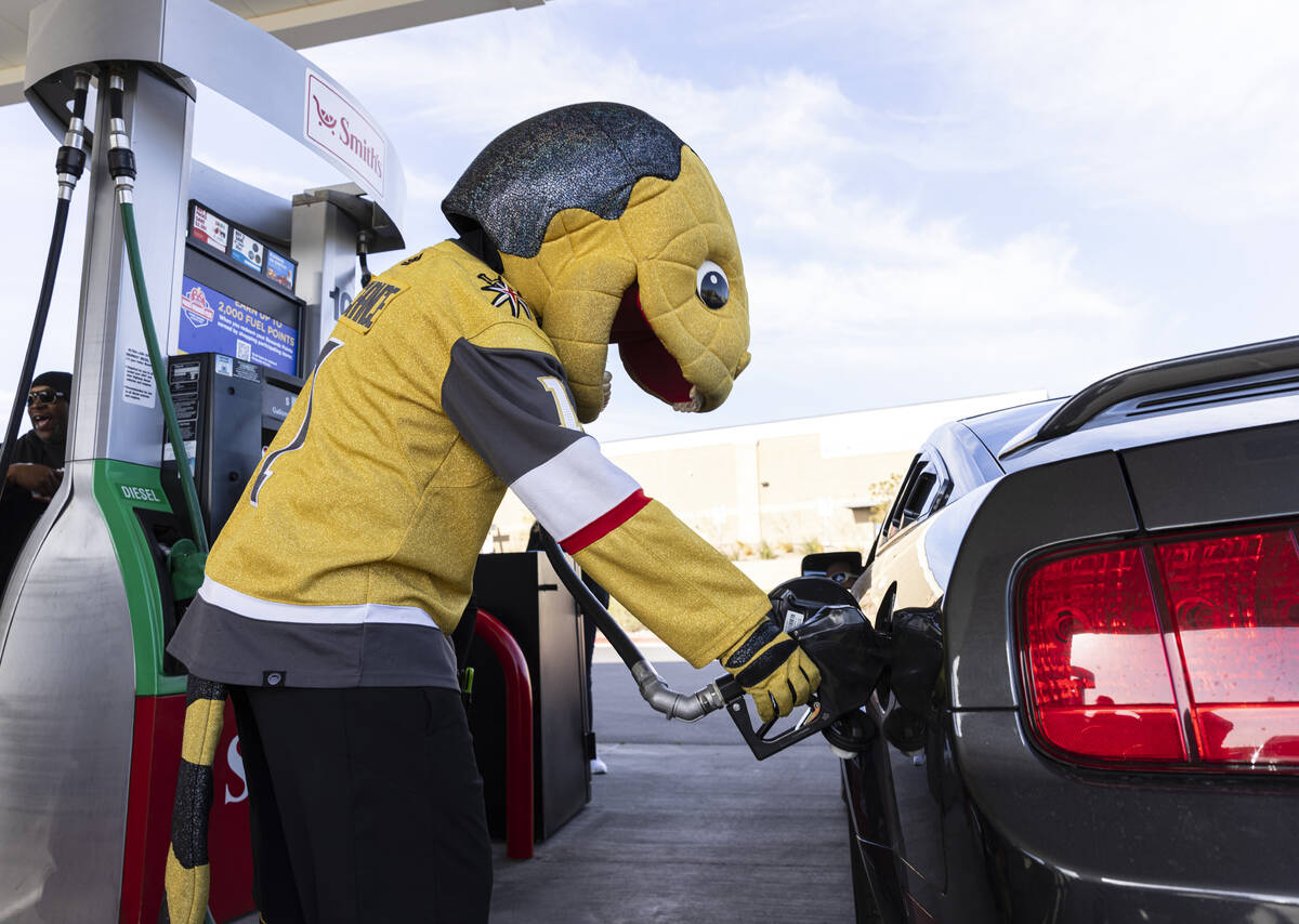 Golden Knights mascot Chance pumps free gas for a customer at Smith’s Marketplace, on Friday, ...