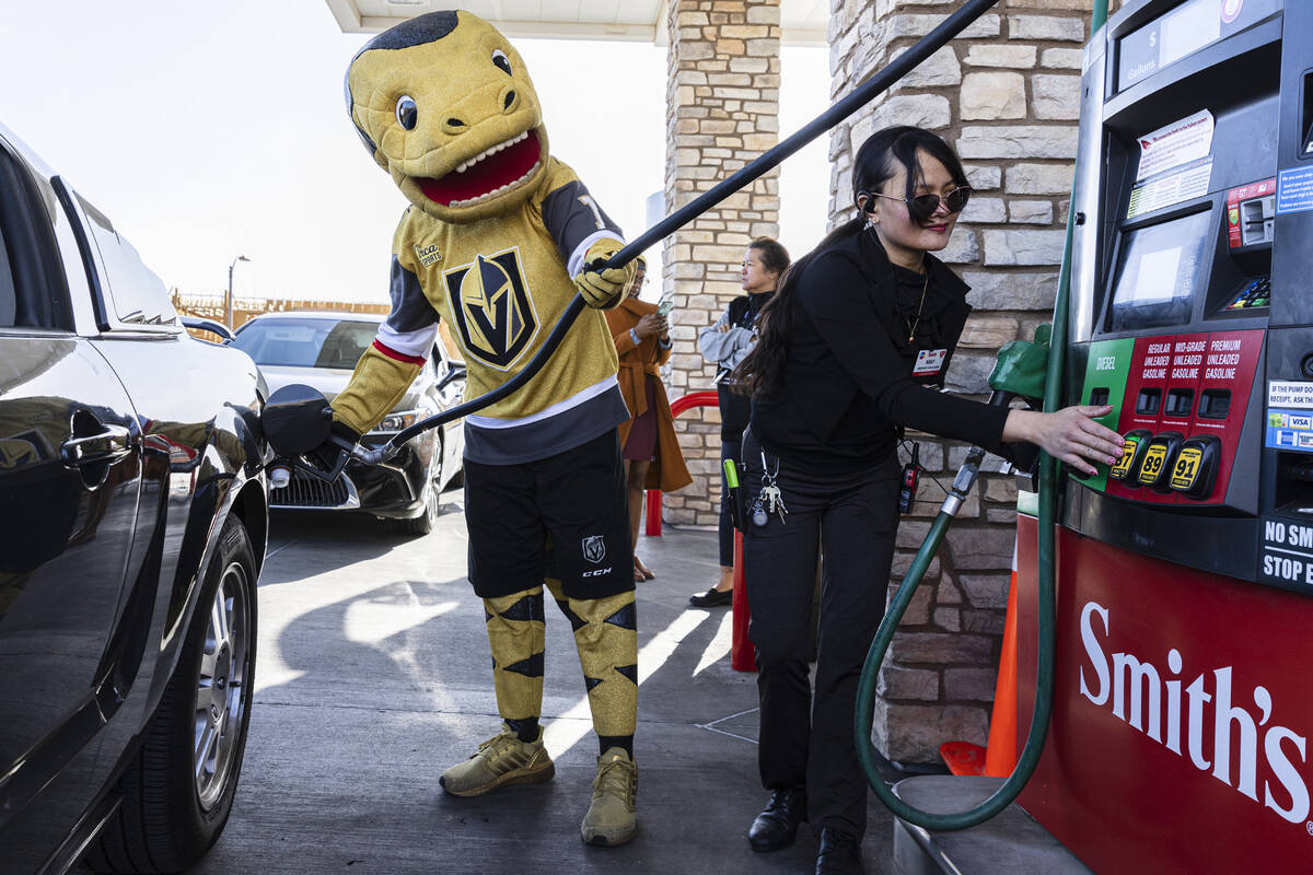 May Woody, right, assistant manager at Smith's, helps Golden Knights mascot Chance pump free ga ...