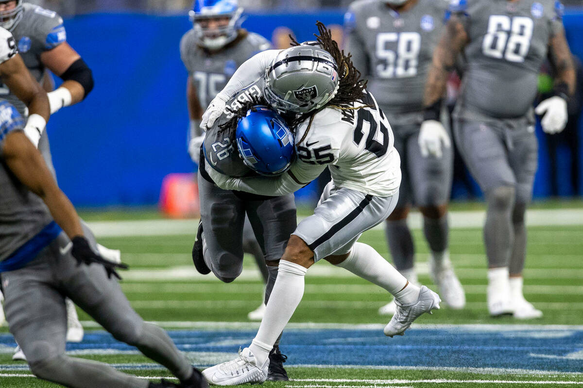 Raiders safety Tre'von Moehrig (25) tackles Detroit Lions running back Jahmyr Gibbs (26) during ...