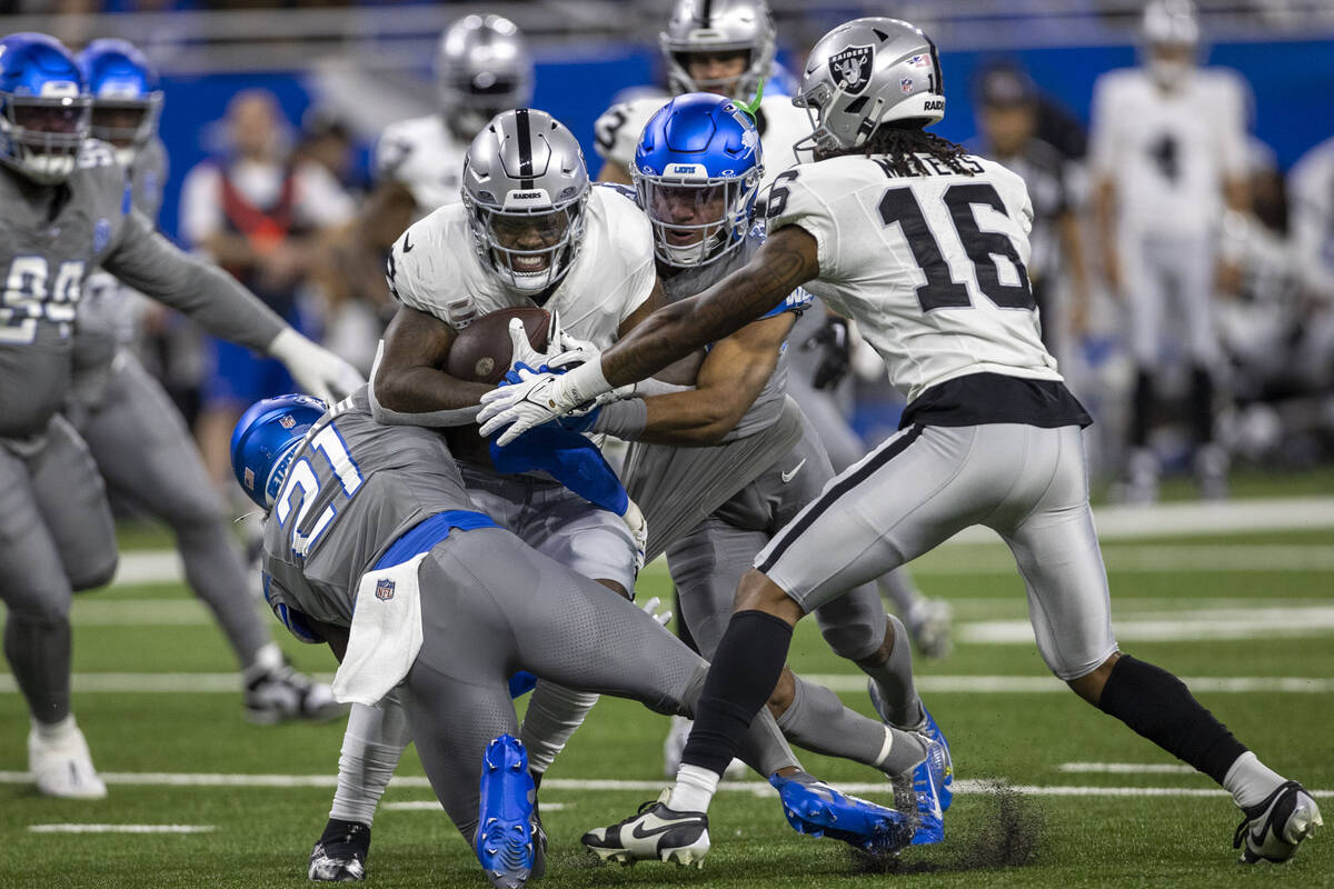 Raiders running back Josh Jacobs (8) pushes for more yards as Detroit Lions safety Tracy Walker ...