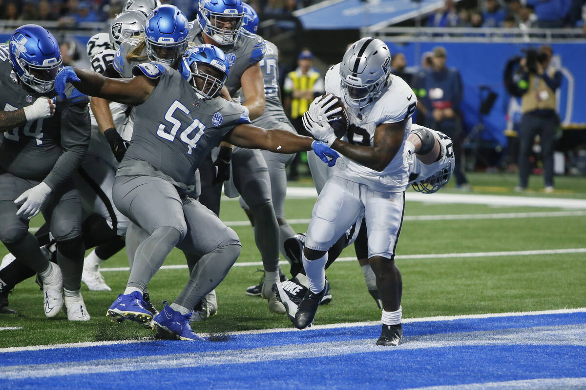 Las Vegas Raiders running back Josh Jacobs (8) breaks the tackle of Detroit Lions defensive tac ...